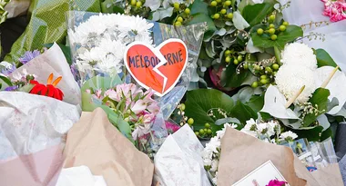 Floral tribute with a heart labeled "Melbourne" among assorted flowers and greenery.