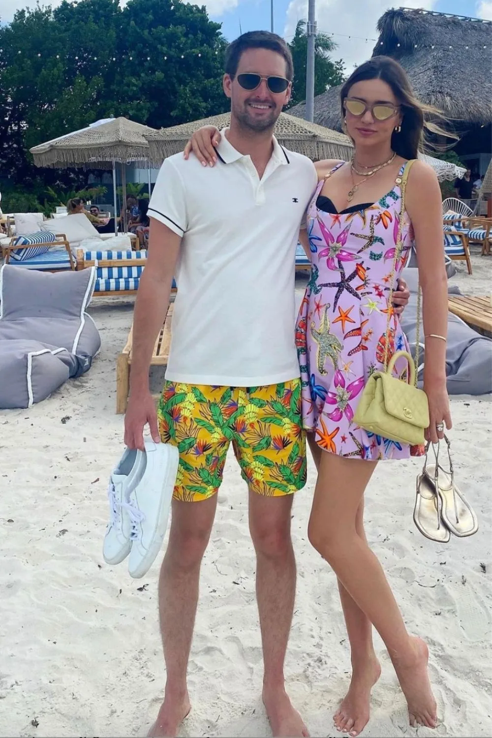 Miranda Kerr wears a pink dress and stands on the beach with her husband Evan Spiegel