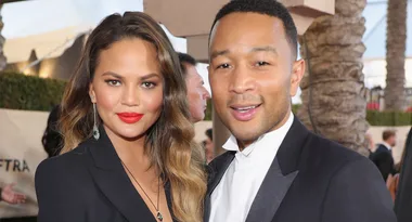I'm sorry, I don't know who these people are. A woman and man dressed formally, smiling at an outdoor event.