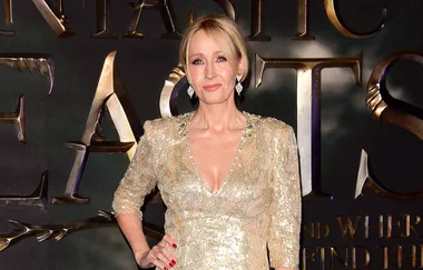 A person in a shimmering gold dress poses at the "Fantastic Beasts" event.