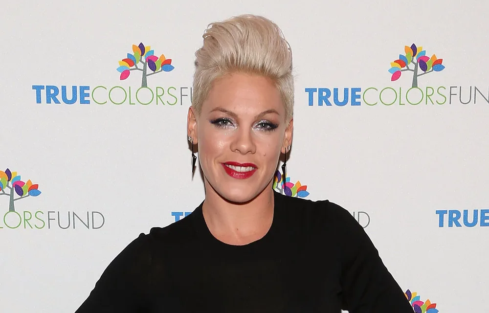 Singer with short blonde hair, wearing black, smiling at the True Colors Fund event.