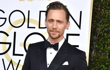Man in a black tuxedo with bow tie at the Golden Globe Awards.