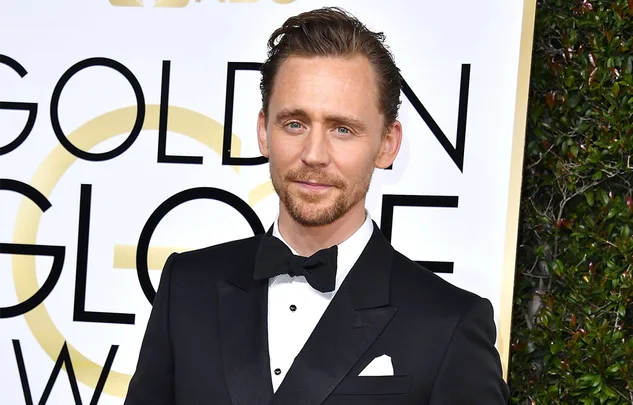 Man in a black tuxedo with bow tie at the Golden Globe Awards.