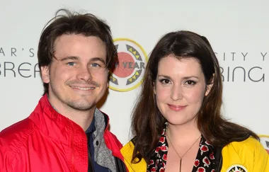 Two people smiling at a City Year event, one wearing a red jacket and the other a yellow jacket.
