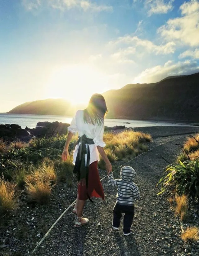 miranda kerr holds hands with her young son Flynn with their backs to the camera