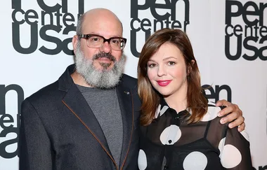 Two smiling individuals pose together at the Pen Center USA event, against a backdrop with the event's logo.