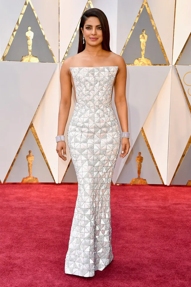 A woman in a strapless geometric patterned gown on the red carpet at an awards event.