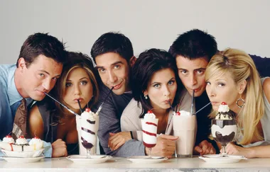 Six people from the TV show "Friends" drinking milkshakes together at a counter.