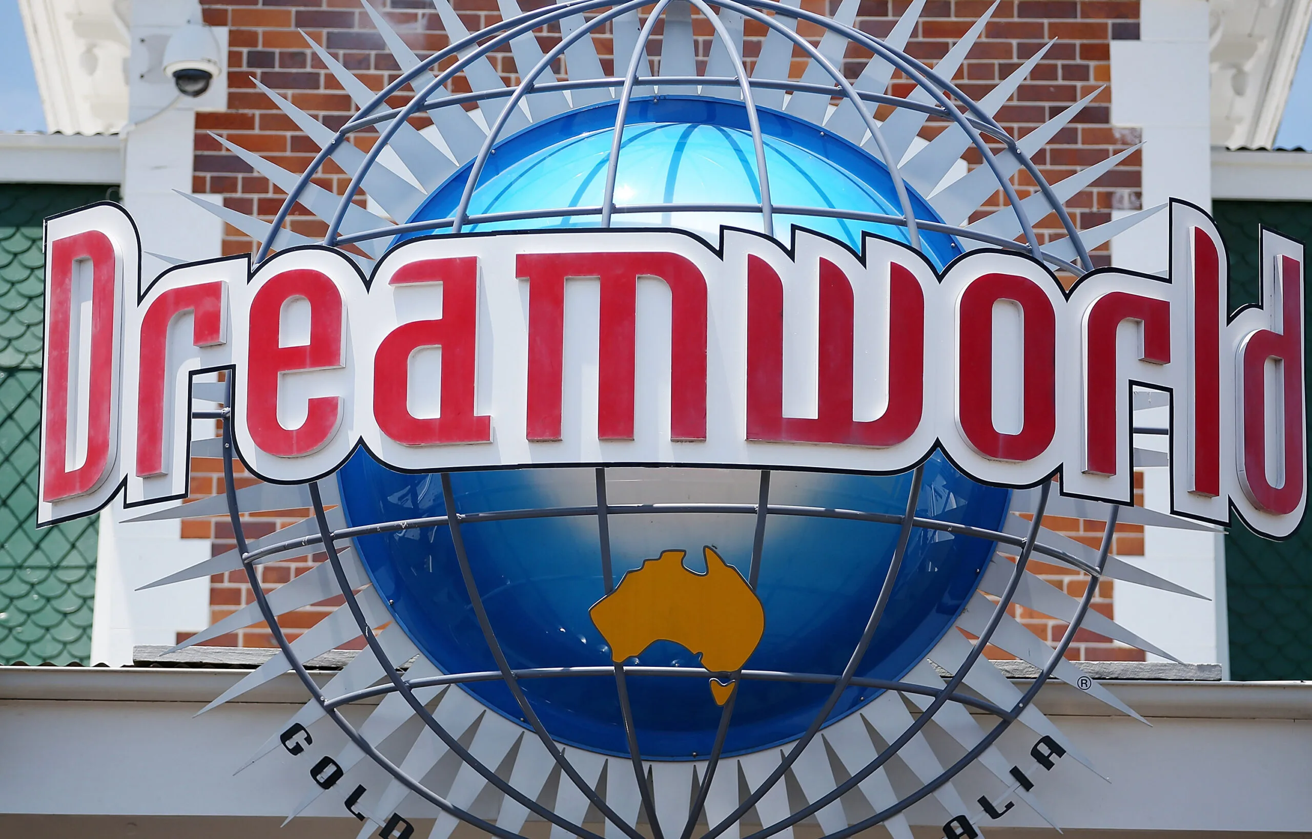Dreamworld theme park sign with red letters on a globe and a yellow Australia map.