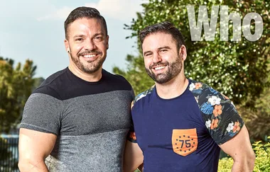 Two smiling men standing outdoors with trees in the background. The word "Who" is visible in the top right corner.