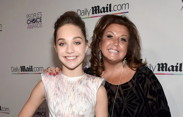 Two individuals smiling at a red carpet event in front of a Daily Mail backdrop.