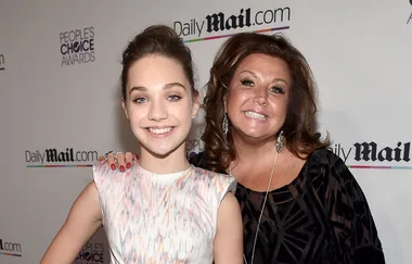 Two individuals smiling at a red carpet event in front of a Daily Mail backdrop.