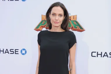 Woman in black dress at "Kung Fu Panda" event backdrop.