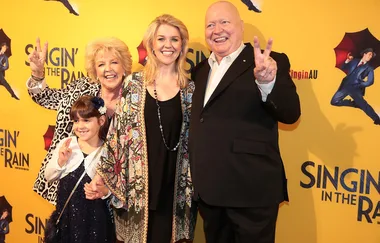 Four people posing for a photo at the "Singin' in the Rain" event, with a yellow backdrop.