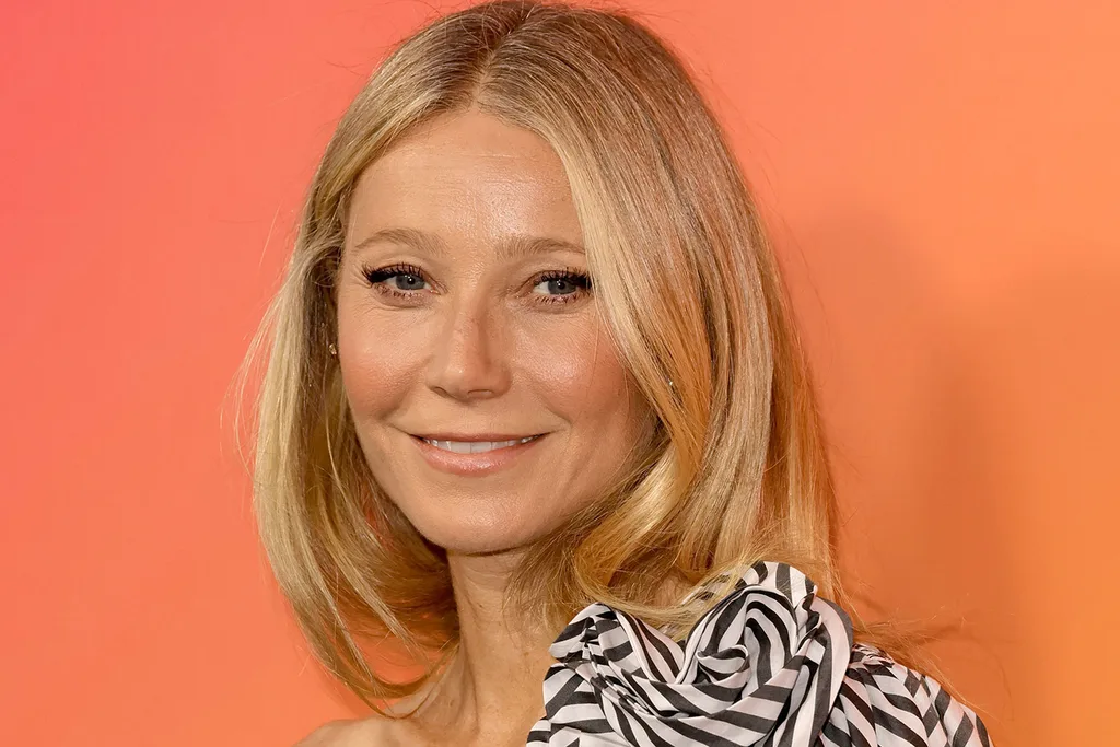 Gwyneth-paltrow-posing-for-a-red-carpet-photo-in-front-of-an-orange-backdrop