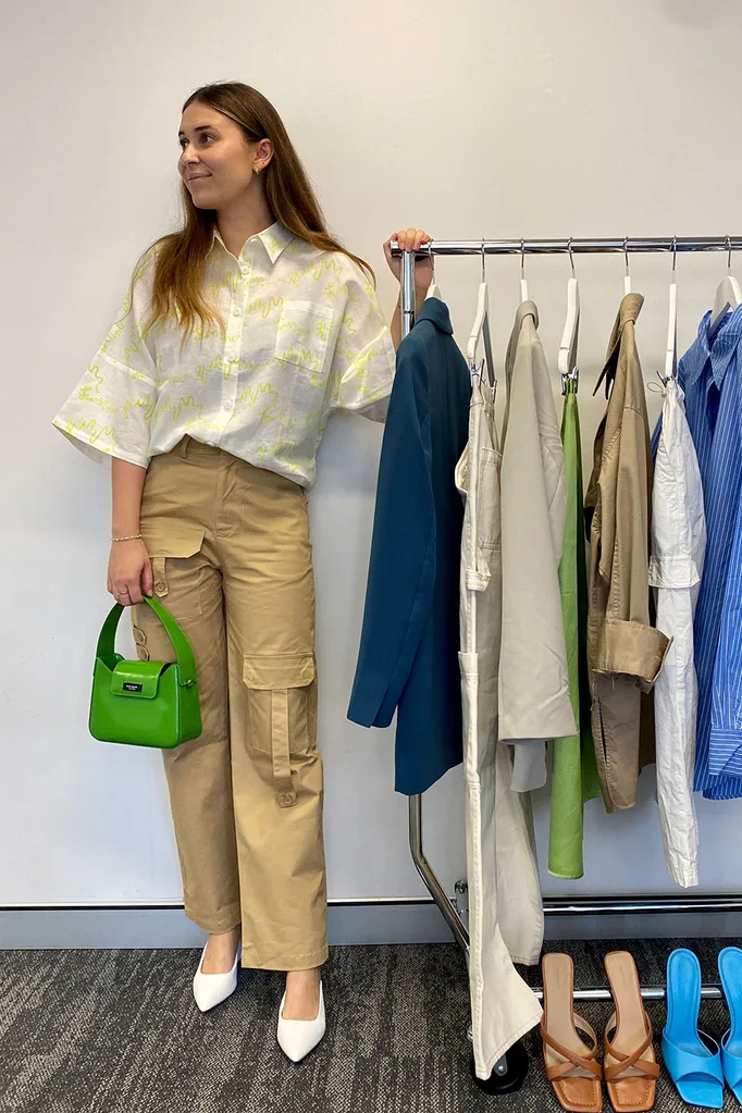 woman-wears-cargo-pants-button-up-shirt-white-heels-and-green-bag