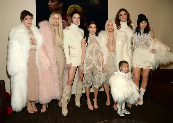 A group of people dressed in coordinated cream and beige outfits, with some wearing faux fur.