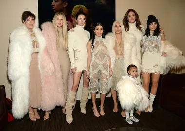 A group of people dressed in coordinated cream and beige outfits, with some wearing faux fur.