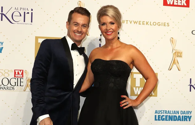 A man in a tuxedo and a woman in a black dress smile at the TV Week Logie Awards 2016.