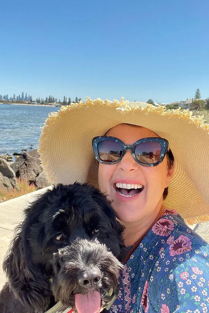 julia-morris-smiling-with-sunglasses-hat-and-dog-in-sunshine