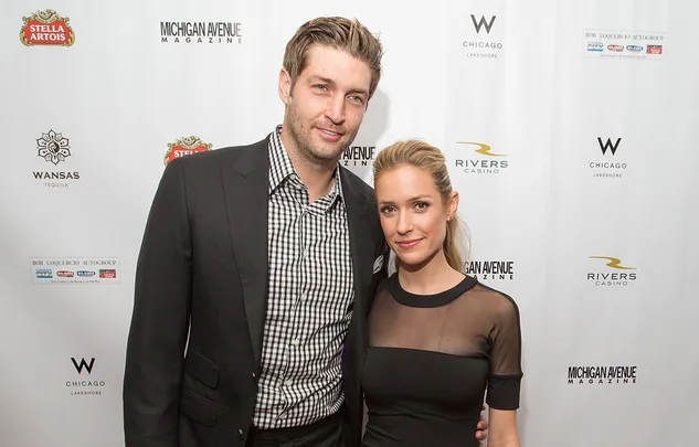 Two people posing together at a Michigan Avenue Magazine event, with branded logos in the background.