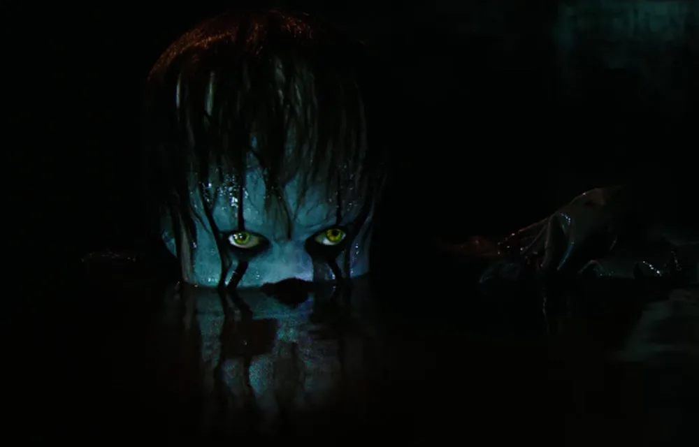 Creepy clown with yellow eyes emerging from dark water, with wet hair obscuring face.
