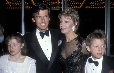 A family of four dressed in formal attire at an event, standing together and smiling.