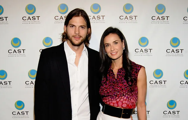 A man and woman pose together in front of a CAST (Coalition to Abolish Slavery & Trafficking) backdrop.
