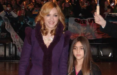 Two people at an event, surrounded by a crowd and a "Harry Potter" banner in the background.