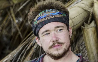 A person with a beard wearing a "Millennials vs. Gen X" bandana. Background has palm fronds and wood.