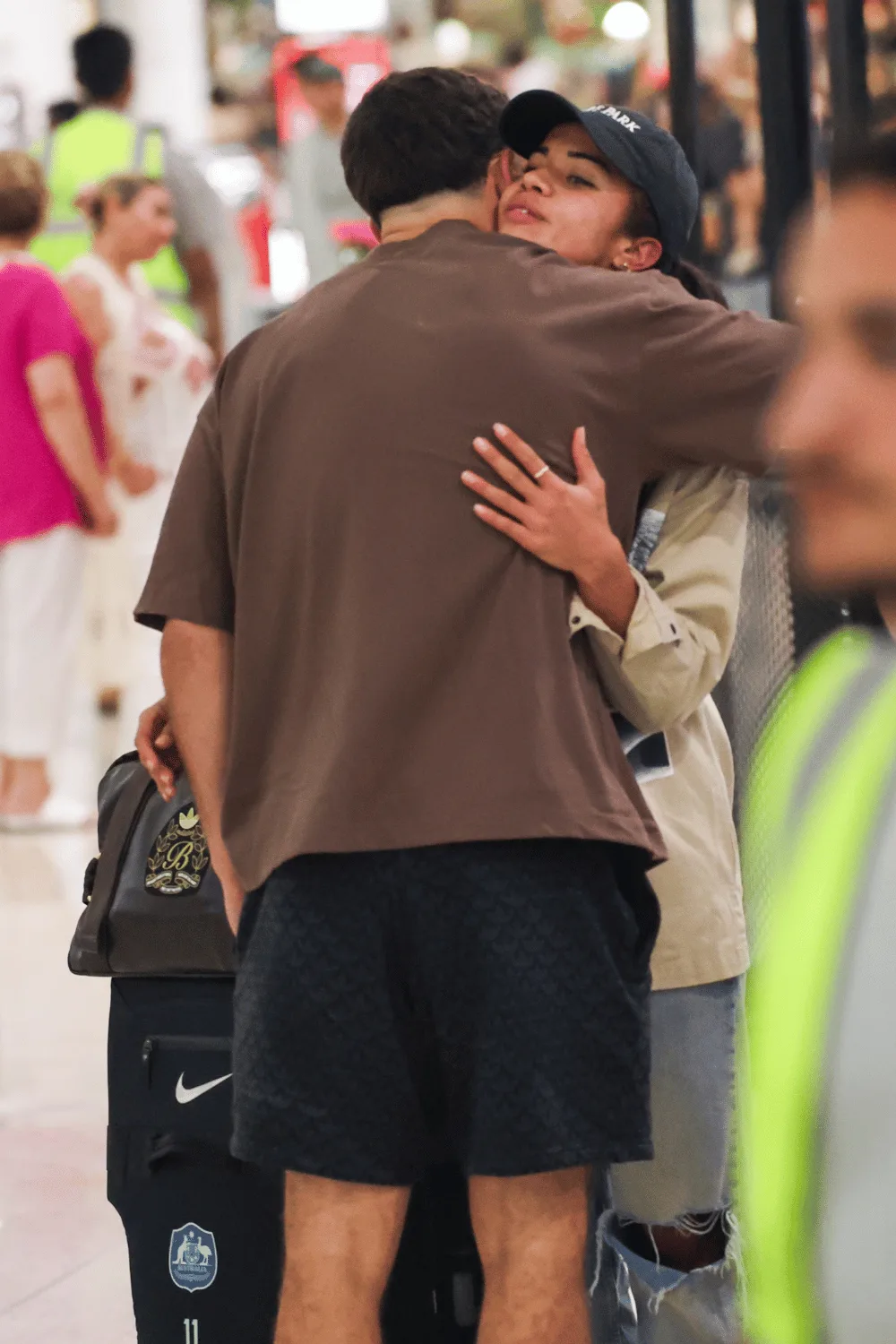 Mary Fowler and Nathan Cleary hugging at Sydney airport. 