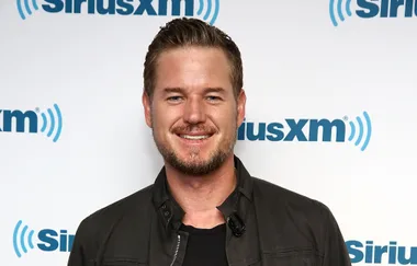 Man smiling at a SiriusXM event, wearing a dark jacket.