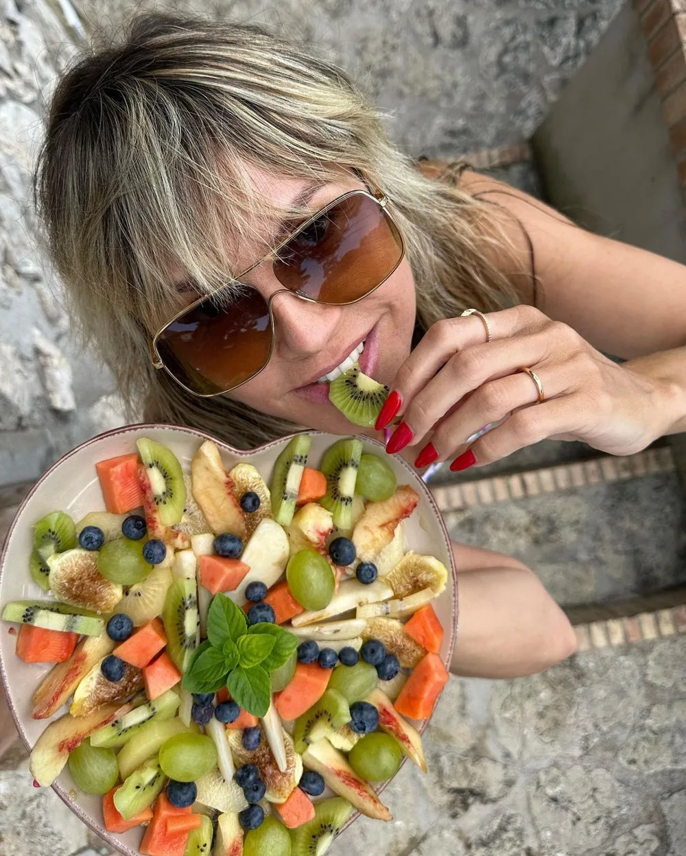 Heidi Klum eating a plate of fruit