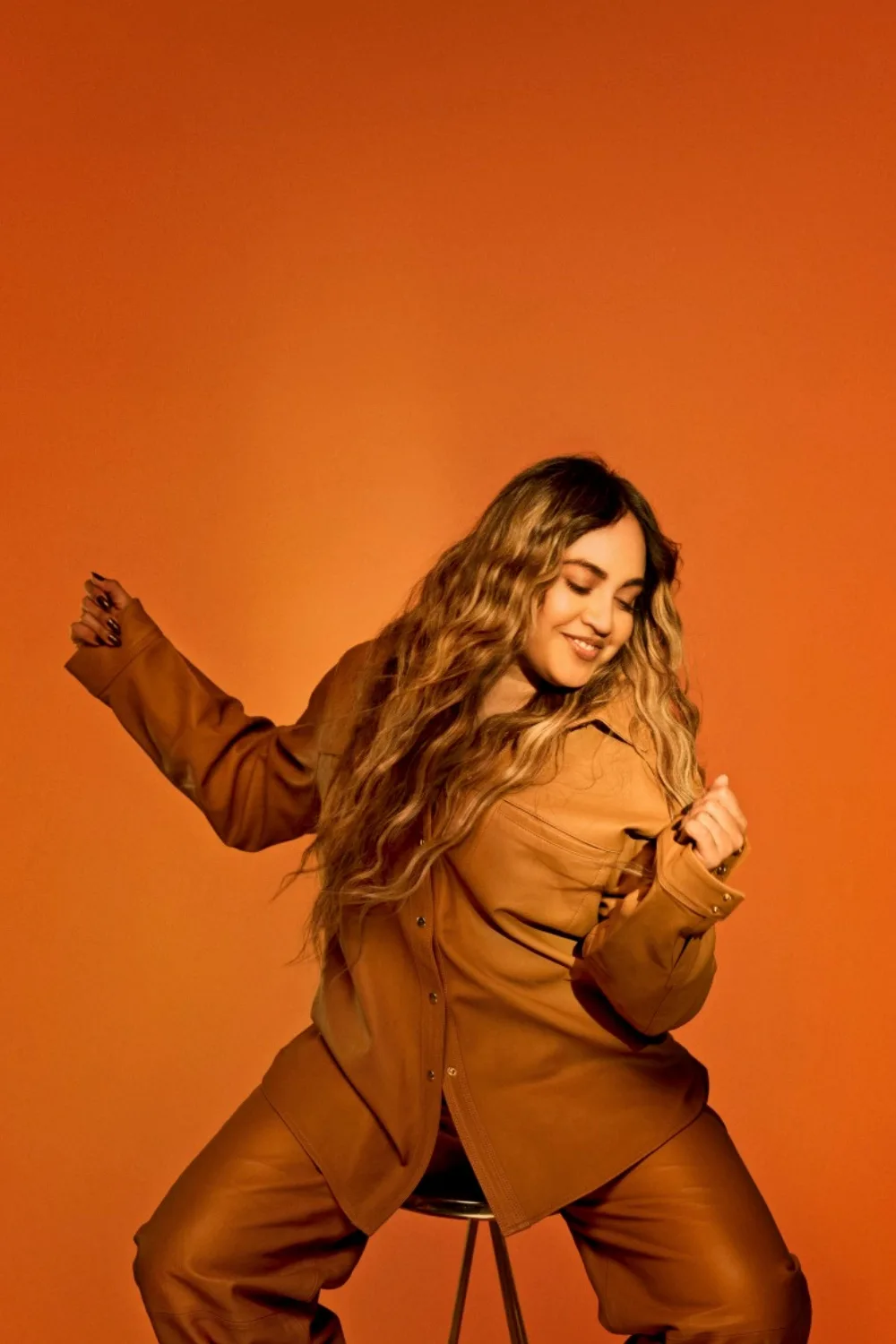 Jessica Mauboy sits on a stool