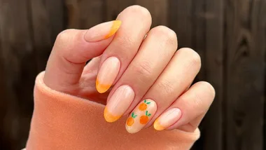 orange french tip nails with oranges on an accent nail