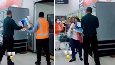 Shoppers line up as employees hand out toilet paper from dock