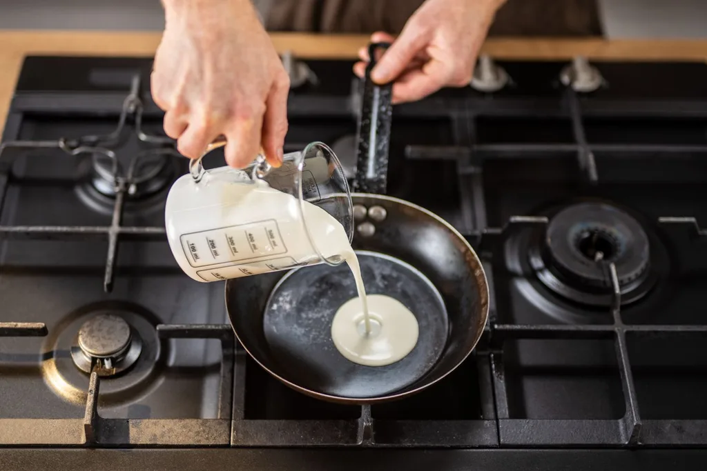 chef pouring cream into a pan