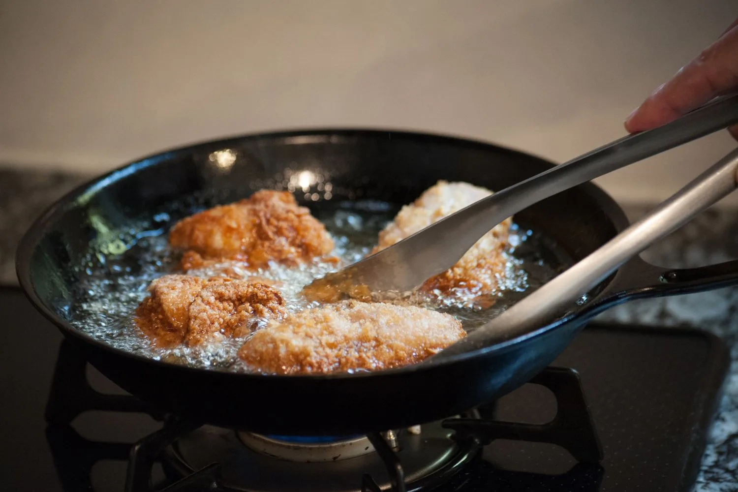 deep fried chicken being cooked in a fry pan