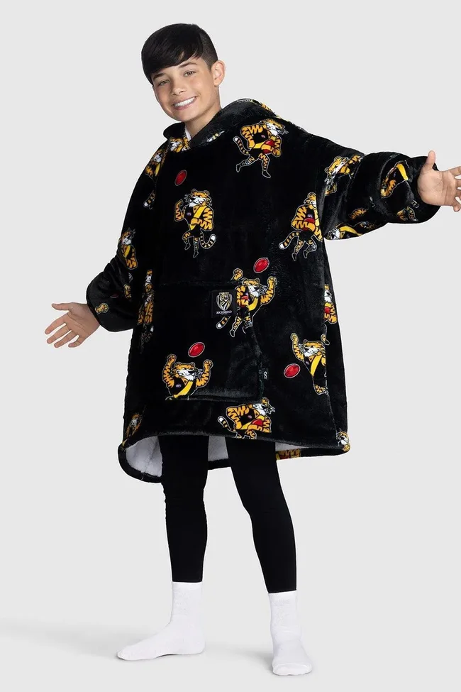 Boy in black Oodie with tiger and ball print, wearing black leggings and white socks, smiling with arms open.