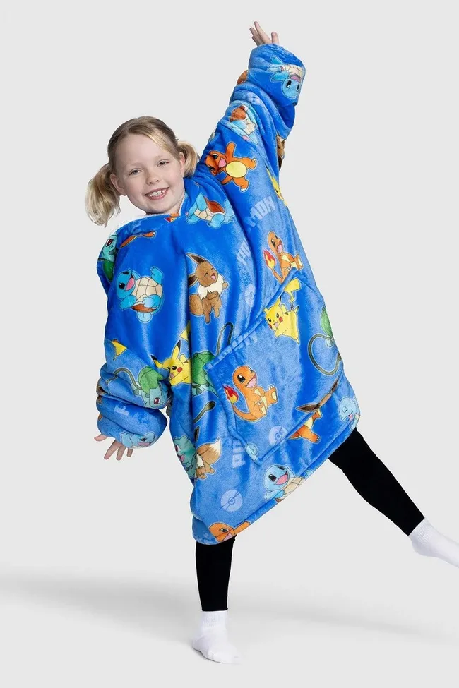 Child wearing a blue Oodie with Pok&eacute;mon characters like Pikachu and Charmander, smiling and posing happily.