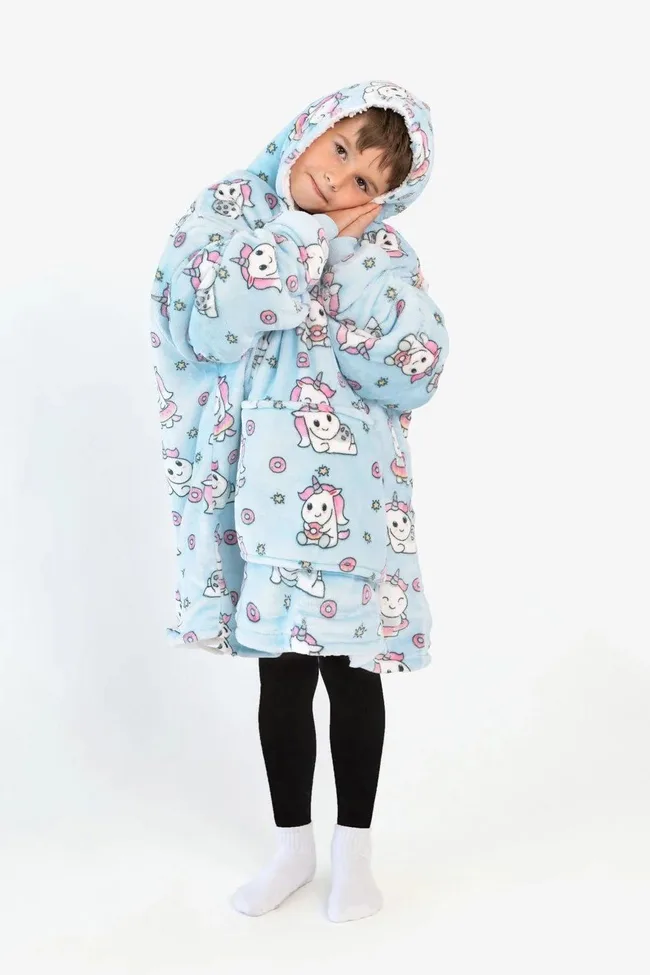 Child wearing a blue unicorn-themed Oodie with a cozy hood, standing with hands clasped.