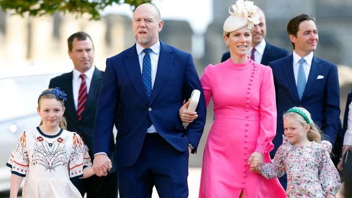 Family walking together in formal attire; two adults and two children dressed up for a public event.