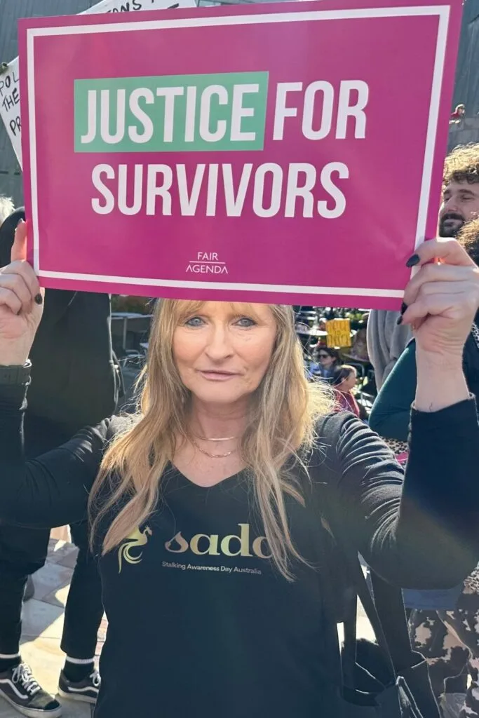 di mcdonalds holding up a sign that reads justice for survivors