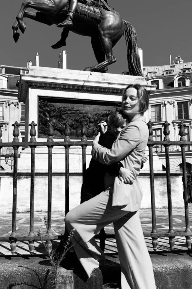 melissa george cuddling her son in front of landmark in paris