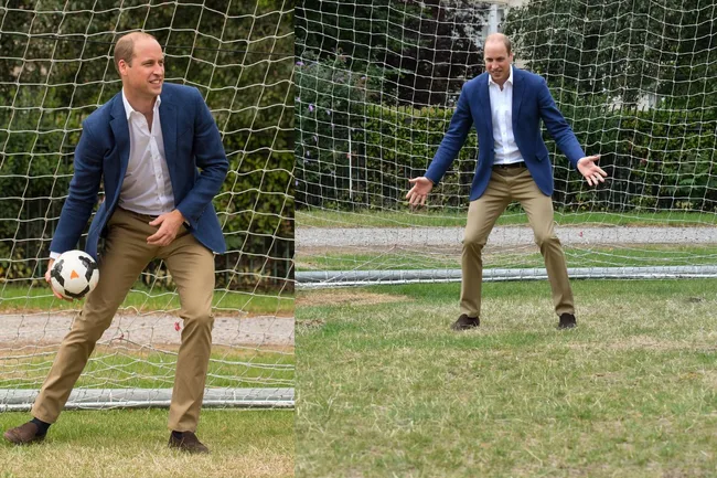 A man in a blue blazer and khaki pants playing soccer as a goalie, standing in front of a goal net on grass.