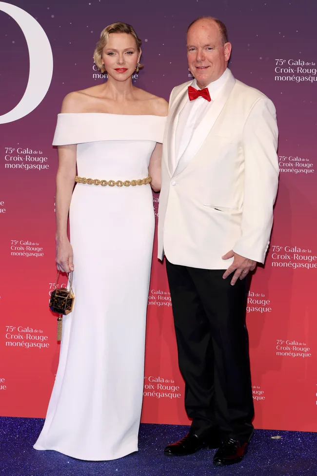 Couple at the 75th Gala de la Croix-Rouge mon&eacute;gasque; woman in white gown, man in white suit with red bowtie.