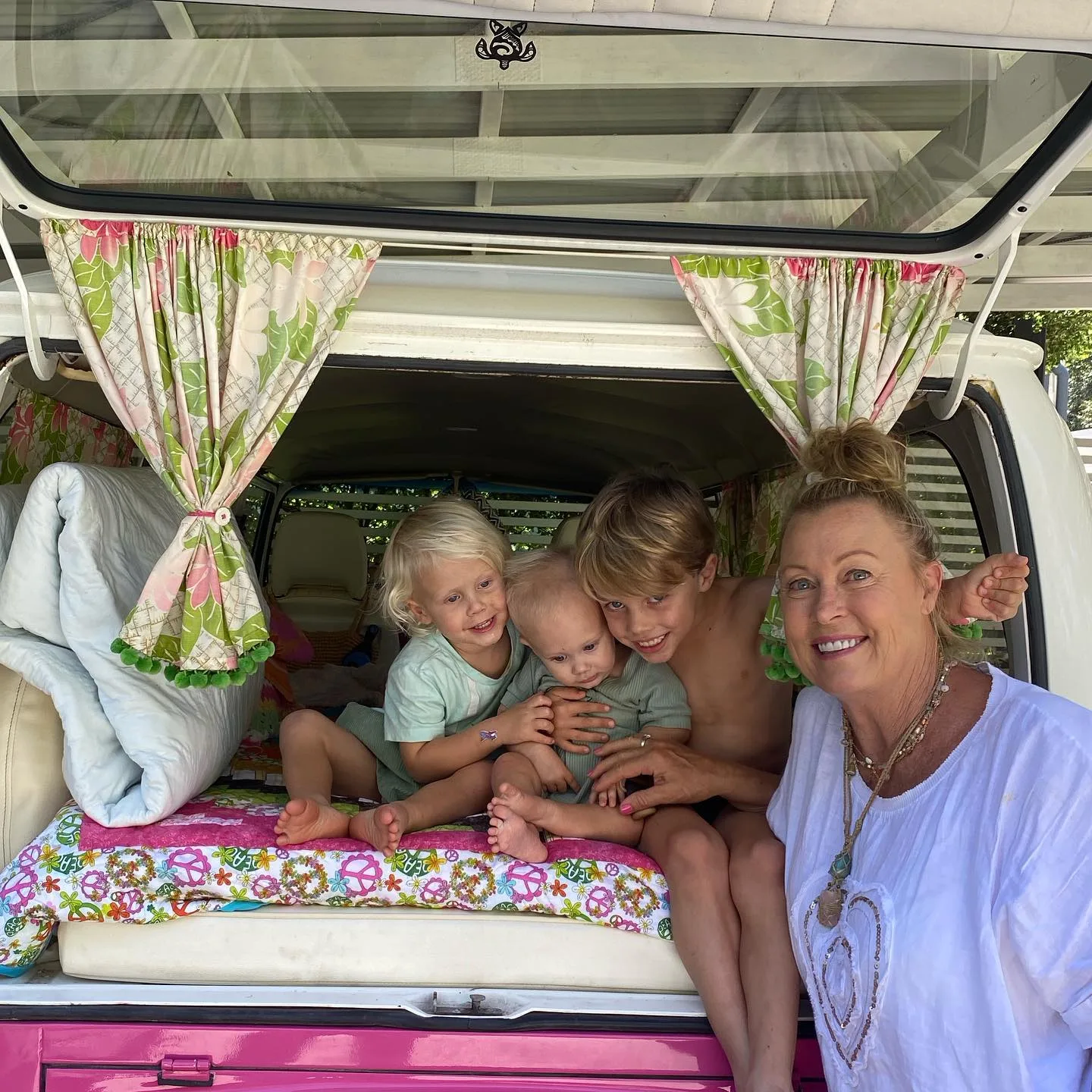 lisa curry with her grandchildren flynn taj and kit in the back of a van
