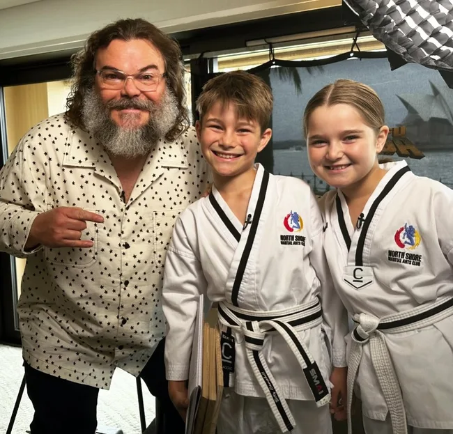 billy and betty campbell pose with jack black while wearing their karate uniform