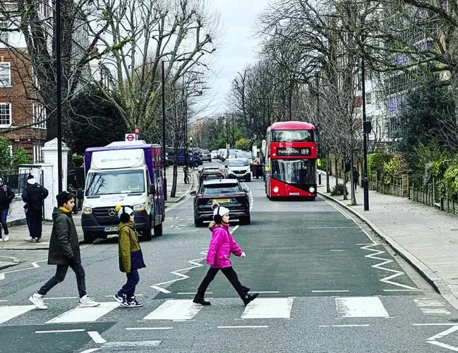 david campbells kids posing as the beatles on a street crossing on Abbey Road in London