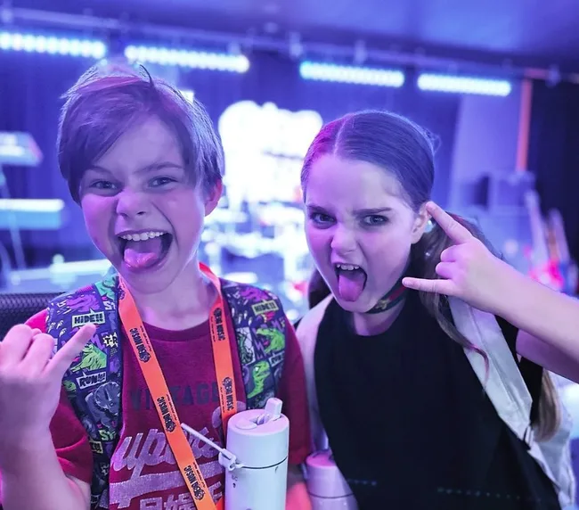 billy and betty hold up the rock sign and put their tongue out